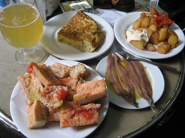 Pan con tomate, anchoas, tortilla y patatas bravas - copyright cvander, Creative Commons License